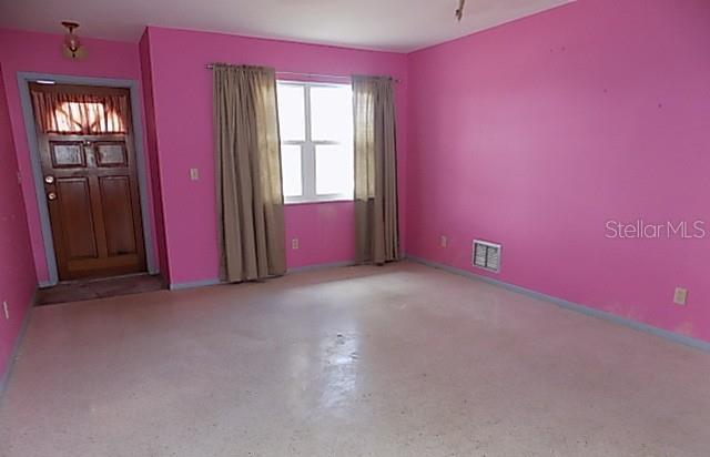 An empty room with bright pink walls, a wooden door, and a window with curtains — 175 ENGLEWOOD HEIGHTS ROAD, ENGLEWOOD, FL