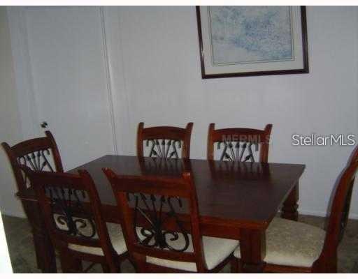 A dining room features a wooden table with six chairs and a framed wall picture — 7681 DARCI RIDGE COURT, KISSIMMEE, FL