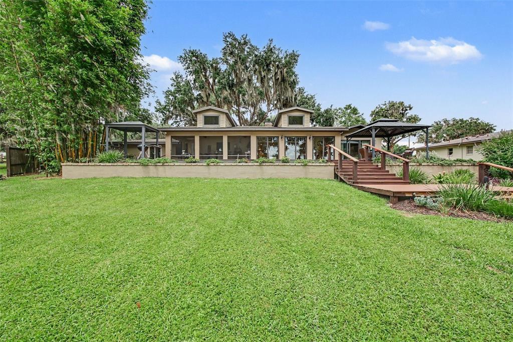 A house exterior features a large lawn, a raised patio, and two covered gazebos — 30139 JOHNSONS POINT ROAD, LEESBURG, FL