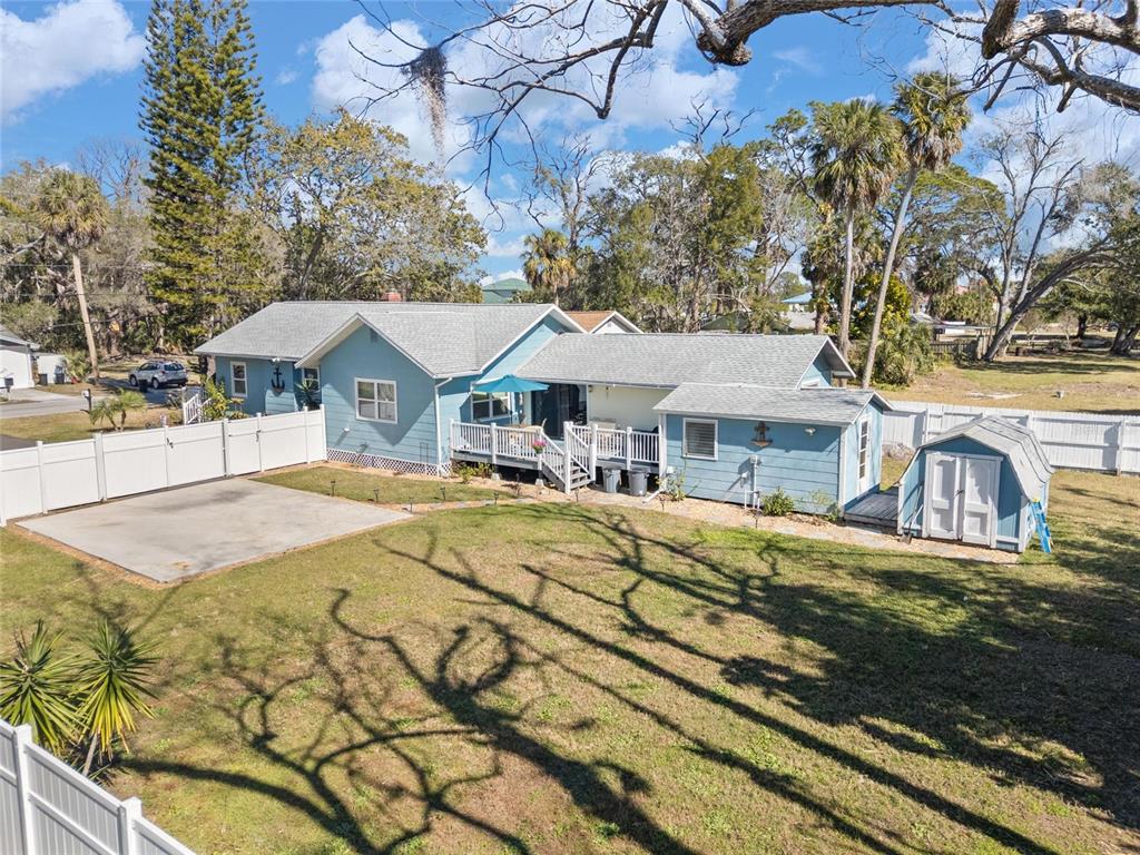 A light blue house with a white deck and a detached shed in a fenced yard — 5150 LIMESTONE DRIVE, PORT RICHEY, FL