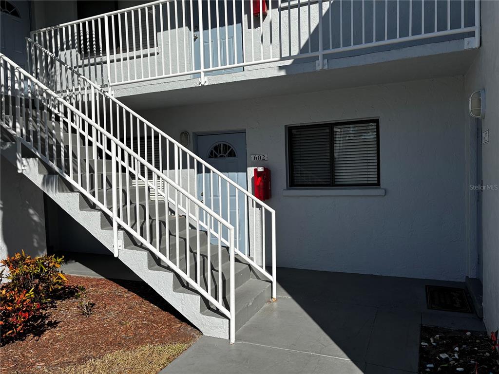 An exterior view of a building entrance with stairs leading to an upper level — 5310 26TH STREET W UNIT 602, BRADENTON, FL