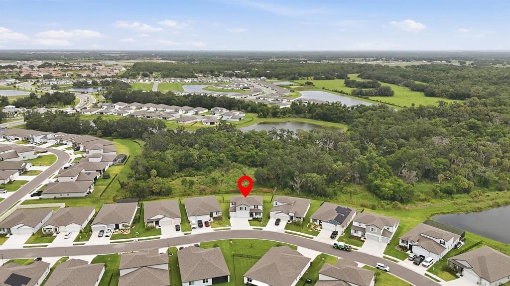 An aerial view shows a suburban neighborhood with a red pin marking a specific house — 14026 GINNIE SPRINGS WAY, PARRISH, FL