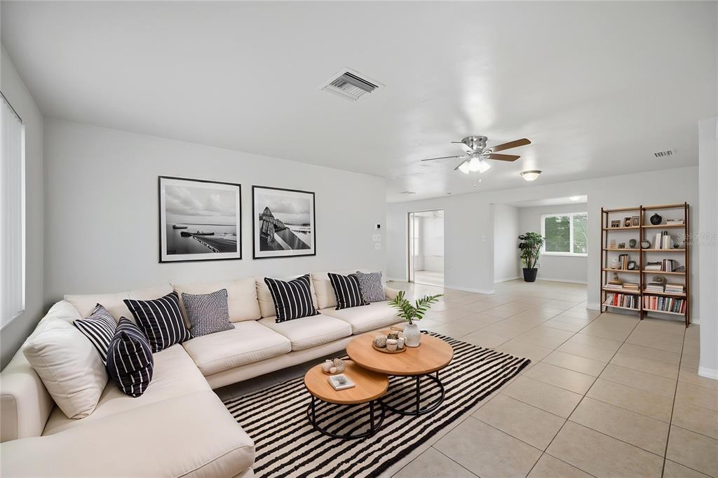 A living room features a white sectional sofa, striped rug, and wooden coffee tables — 3029 HUNTINGTON ROAD, HOLIDAY, FL