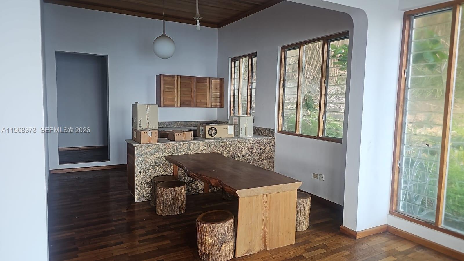 A kitchen features a granite island, a live-edge wood table, and tree-stump stools — 00 Oracabessa, St. Mary, NA, NA