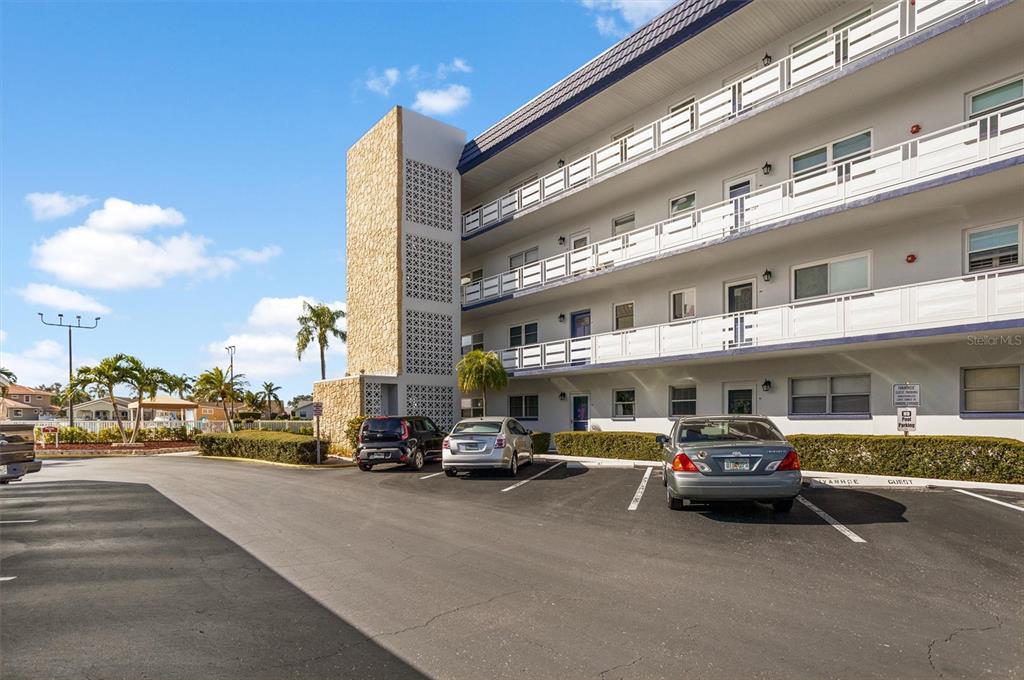 A multi-story apartment building with exterior walkways and a parking lot in the foreground — 5955 30TH AVENUE S UNIT 202, GULFPORT, FL