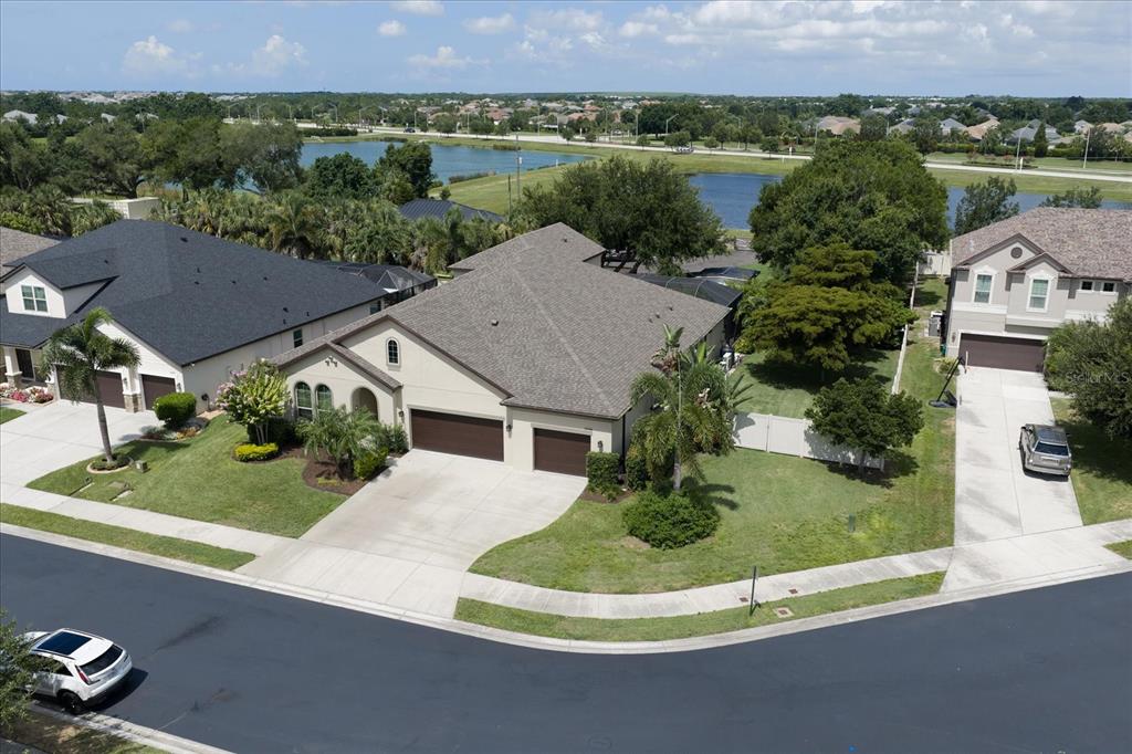 An aerial view shows a suburban house with a three-car garage and a corner lot — 12940 BLISS LOOP, BRADENTON, FL