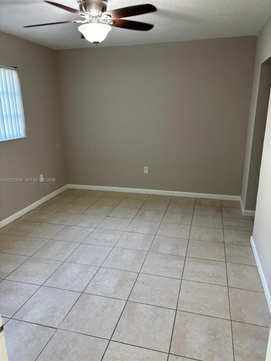 An empty room features beige tile flooring, light brown walls, and a ceiling fan — 3050 S Dixie Hwy # 203, Miami FL 33133, MIAMI, FL
