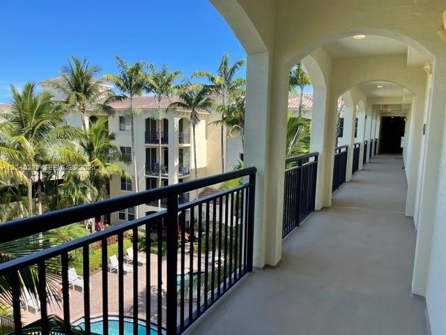 An elevated balcony overlooks a swimming pool and palm trees at a multi-story apartment complex — 2409 Renaissance Way # 409, Boynton Beach FL 33426, BOYNTON BEACH, FL