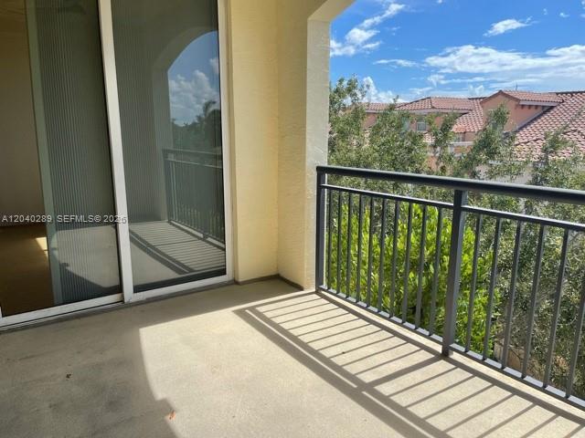 A balcony with a concrete floor, a sliding glass door, and a black metal railing — 2409 Renaissance Way # 409, Boynton Beach FL 33426, BOYNTON BEACH, FL