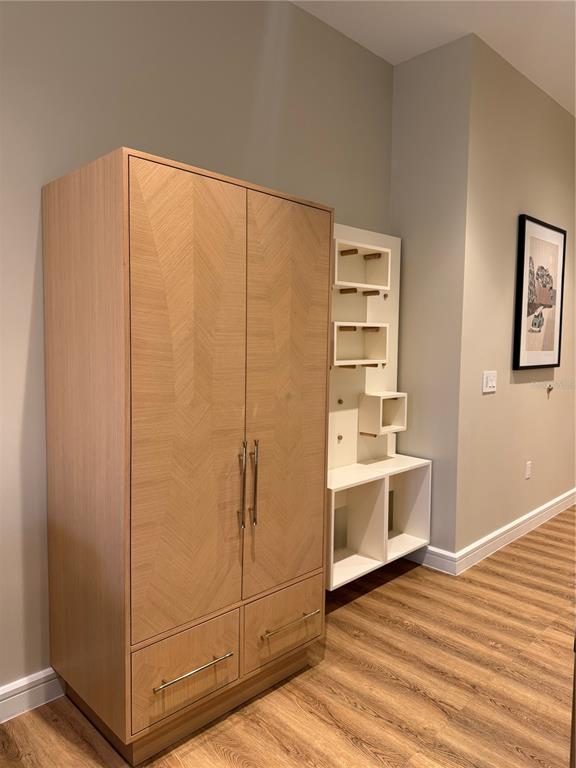 A light wood wardrobe with two drawers stands next to a white open-shelving unit — 3151 SUNSET WALK DRIVE UNIT 416, KISSIMMEE, FL