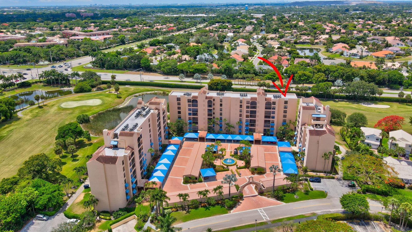 An aerial view of a multi-story apartment complex surrounded by a golf course and trees — 7194 Promenade Drive # 102, Boca Raton FL 33433, BOCA RATON, FL