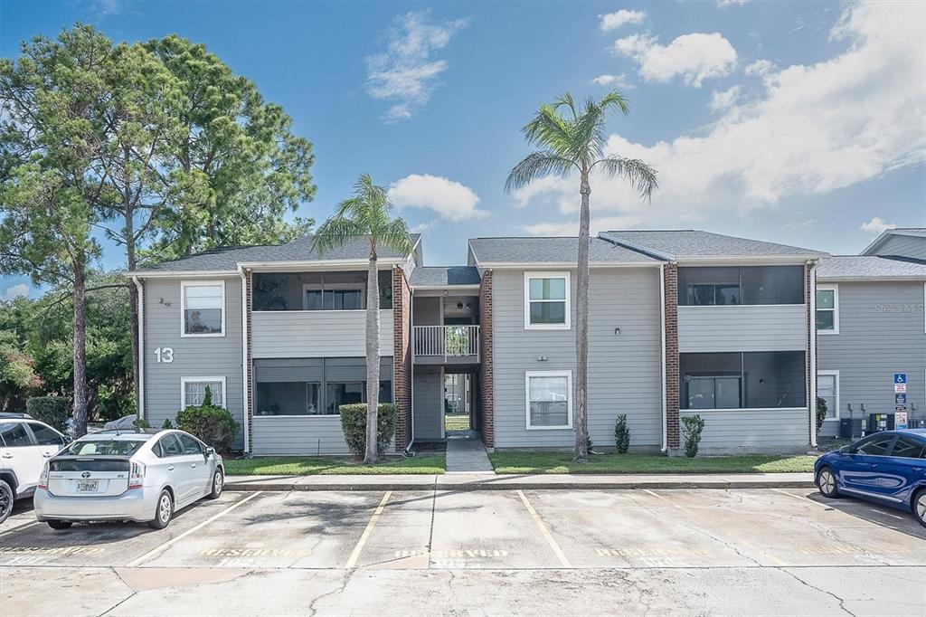 A two-story apartment building with gray siding and parking spaces in the foreground — 1400 GANDY BOULEVARD N UNIT 1306, ST PETERSBURG, FL