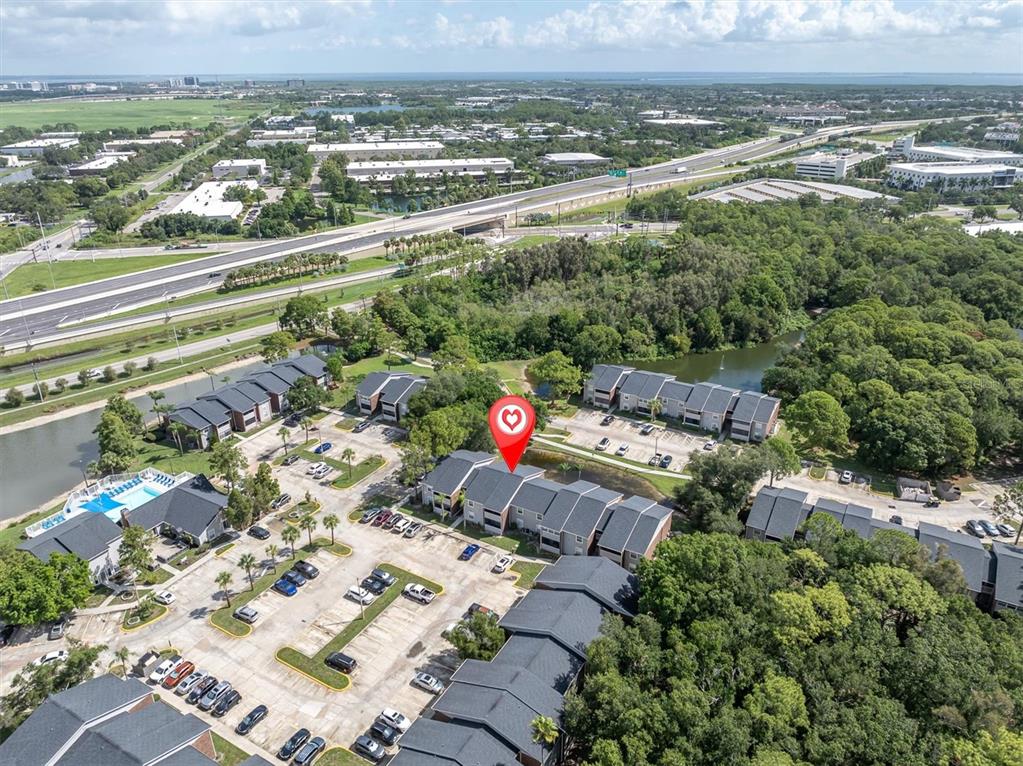 An aerial view shows a multi-family residential complex with parking lots and a nearby highway — 1400 GANDY BOULEVARD N UNIT 1306, ST PETERSBURG, FL