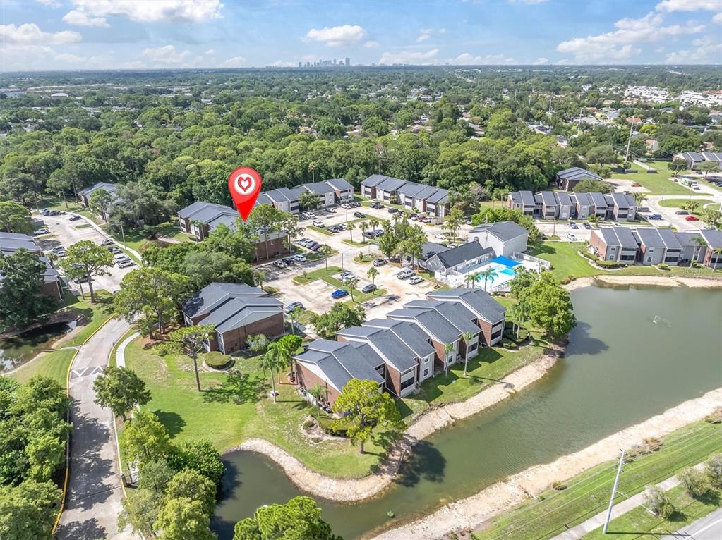 An aerial view shows a multi-building apartment complex with a pool and a pond — 1400 GANDY BOULEVARD N UNIT 1306, ST PETERSBURG, FL