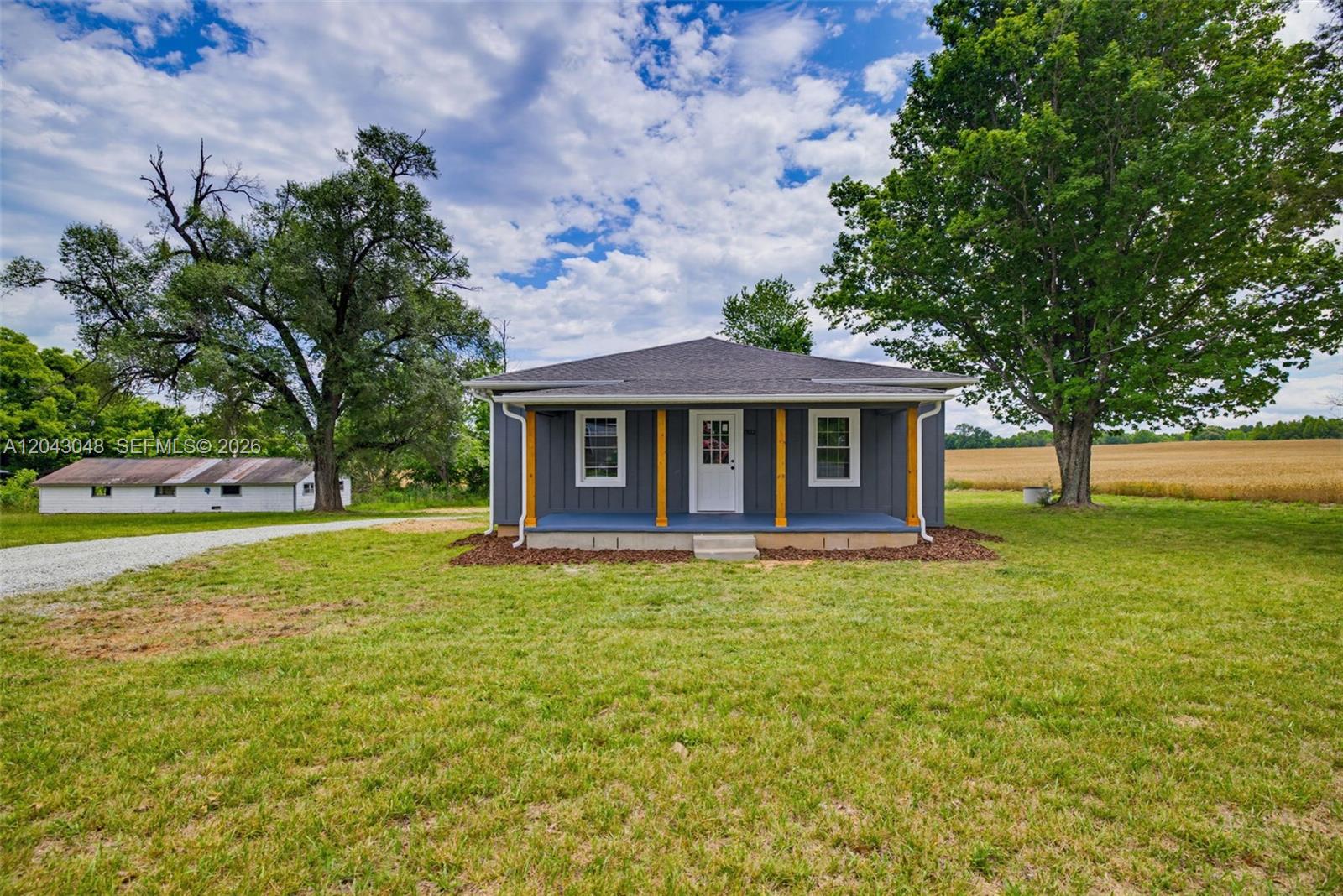 A gray, single-story house with a front porch sits on a grassy lot — 7922 Troxler Mill Road, NC 27249, NC
