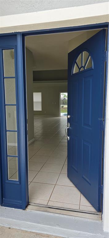 A blue front door opens into a tiled entryway with a view of the interior — 103 RIGGS CIRCLE, DAVENPORT, FL
