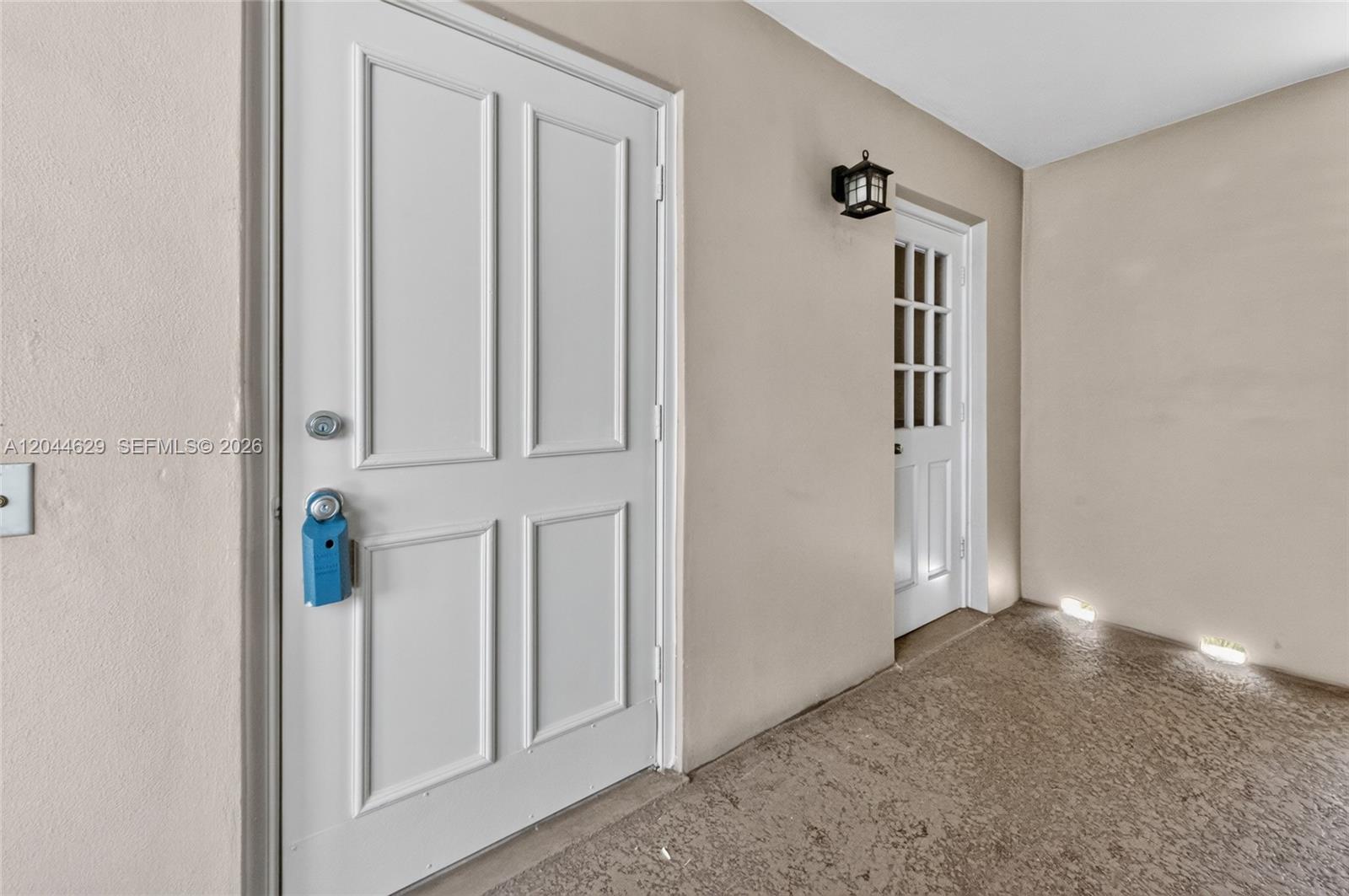 A white door with a blue lockbox sits next to a smaller glass-paneled door — 9101 W Sample Rd # 306, Coral Springs FL 33065, CORAL SPRINGS, FL