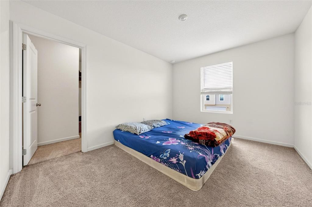 A bedroom with white walls, beige carpeting, a window with blinds, and a floor mattress — 1665 MINNESOTA ROAD, SUMTERVILLE, FL