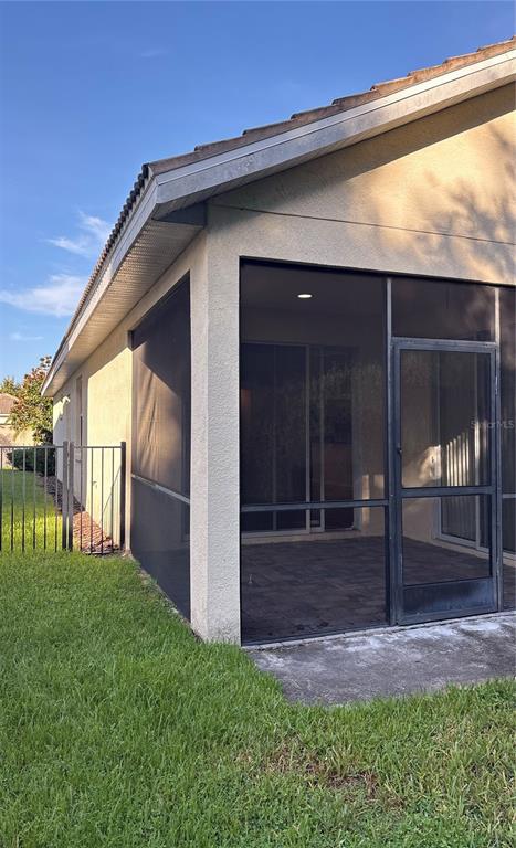 A screened-in patio with a paver floor is attached to the side of a house — 10864 CORY LAKE DRIVE, TAMPA, FL
