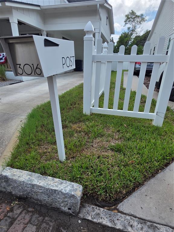 A white mailbox with the number 3016 stands next to a white picket fence — 3016 N MASSACHUSETTS AVENUE, TAMPA, FL