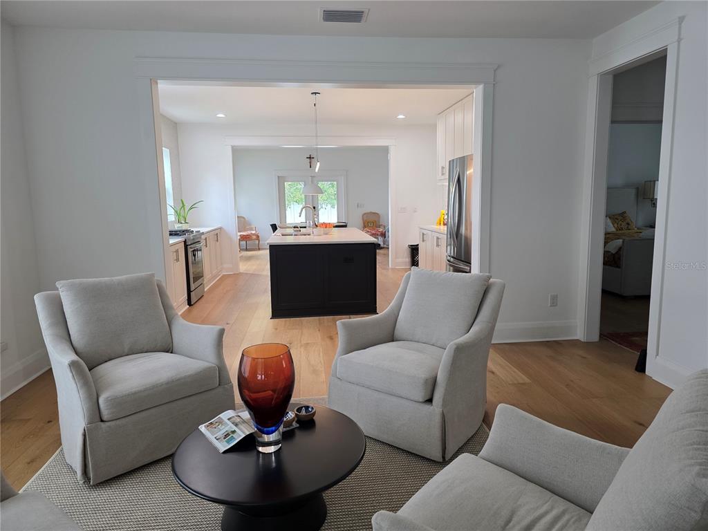 A living area with three armchairs and a coffee table opens into a kitchen — 3016 N MASSACHUSETTS AVENUE, TAMPA, FL