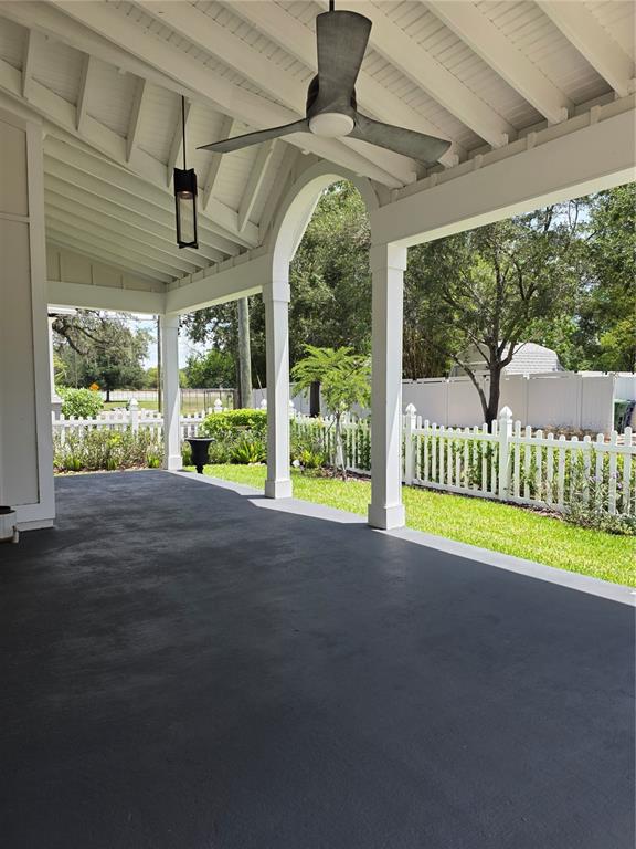 A covered patio features a dark painted floor, white arched columns, and a ceiling fan — 3016 N MASSACHUSETTS AVENUE, TAMPA, FL