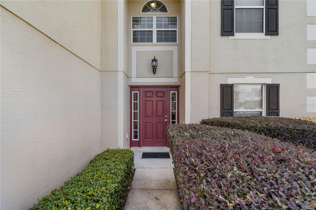 The exterior view shows a red front door with sidelights and a small arched window — 14308 NW 161ST AVENUE, ALACHUA, FL