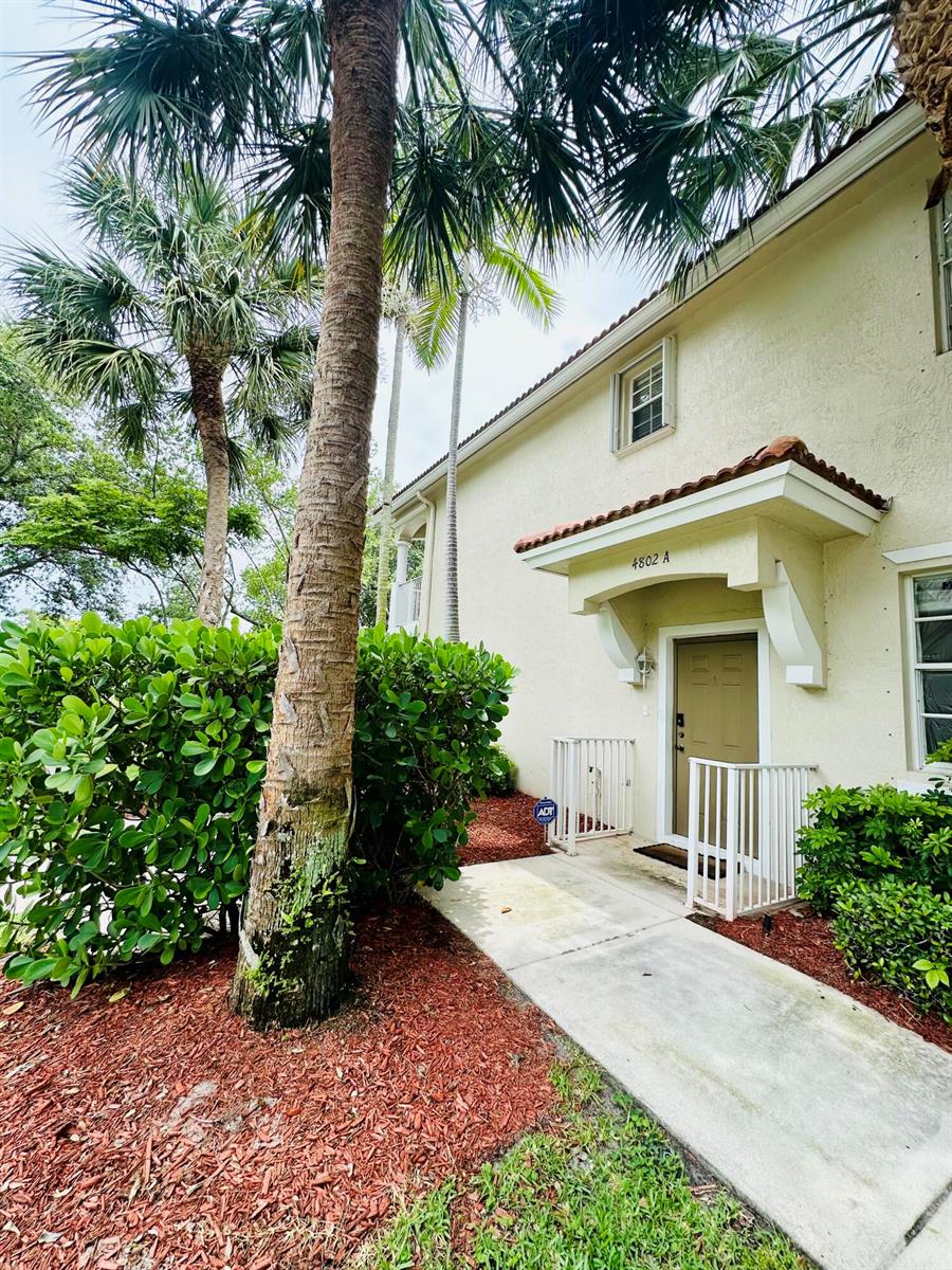 A tan two-story building exterior features a covered entryway labeled 4802 A and palm trees — 4802 W Bexley Park Drive # A, Delray Beach FL 33445, DELRAY BEACH, FL