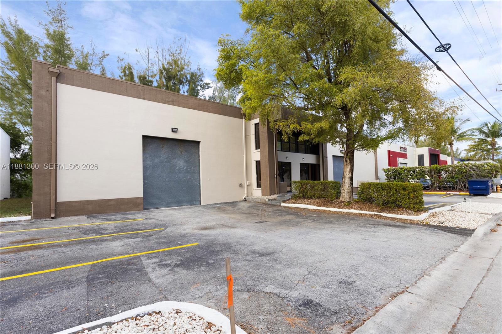 A commercial building with a roll-up door, glass entrance, and paved parking lot — 1740 NW 93 AV # 1740, Doral FL 33172, DORAL, FL