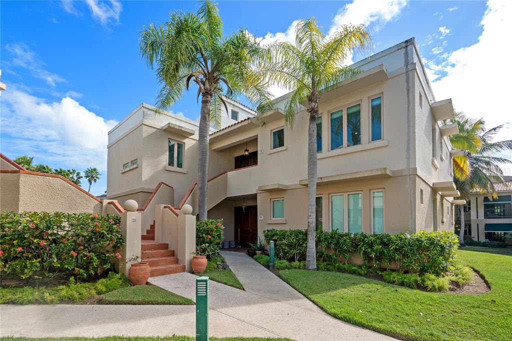 A two-story tan stucco building with palm trees, a concrete walkway, and exterior stairs — 86 LAKESIDE VILLAS UNIT Y4, DORADO, PR