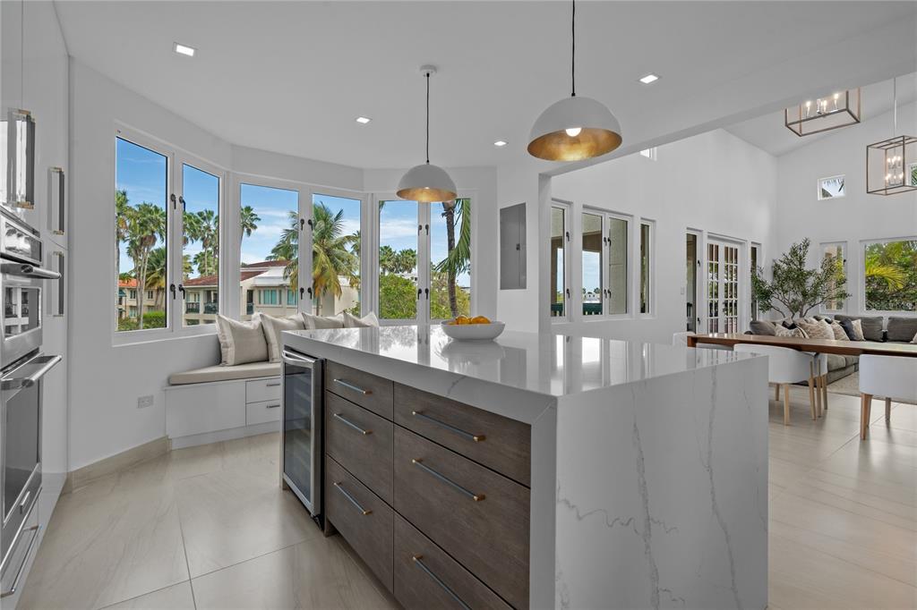 A modern kitchen features a marble-topped island, dark wood cabinetry, and a window-side seating nook — 86 LAKESIDE VILLAS UNIT Y4, DORADO, PR