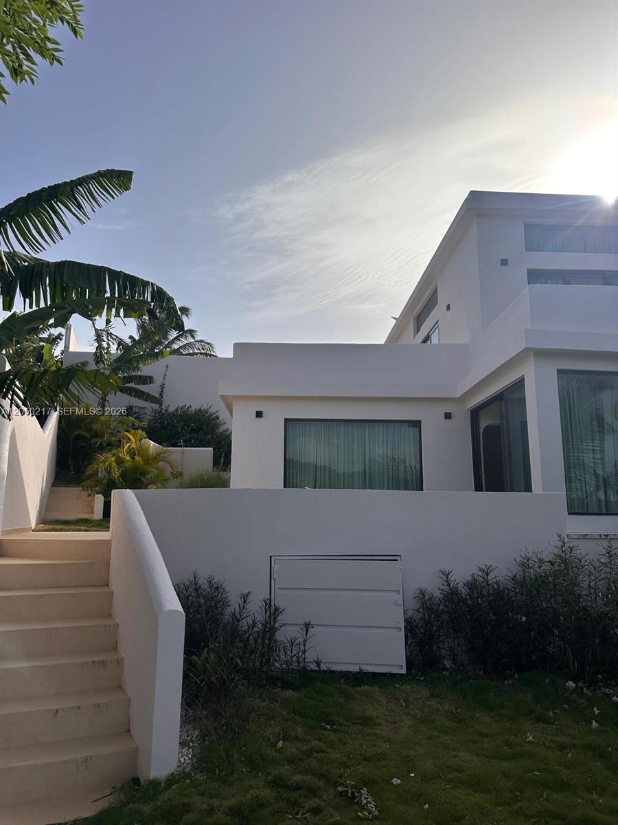 A modern white multi-level house features a staircase, large windows, and surrounding palm trees — 0 LA NOVILLA, AK 99999, AK