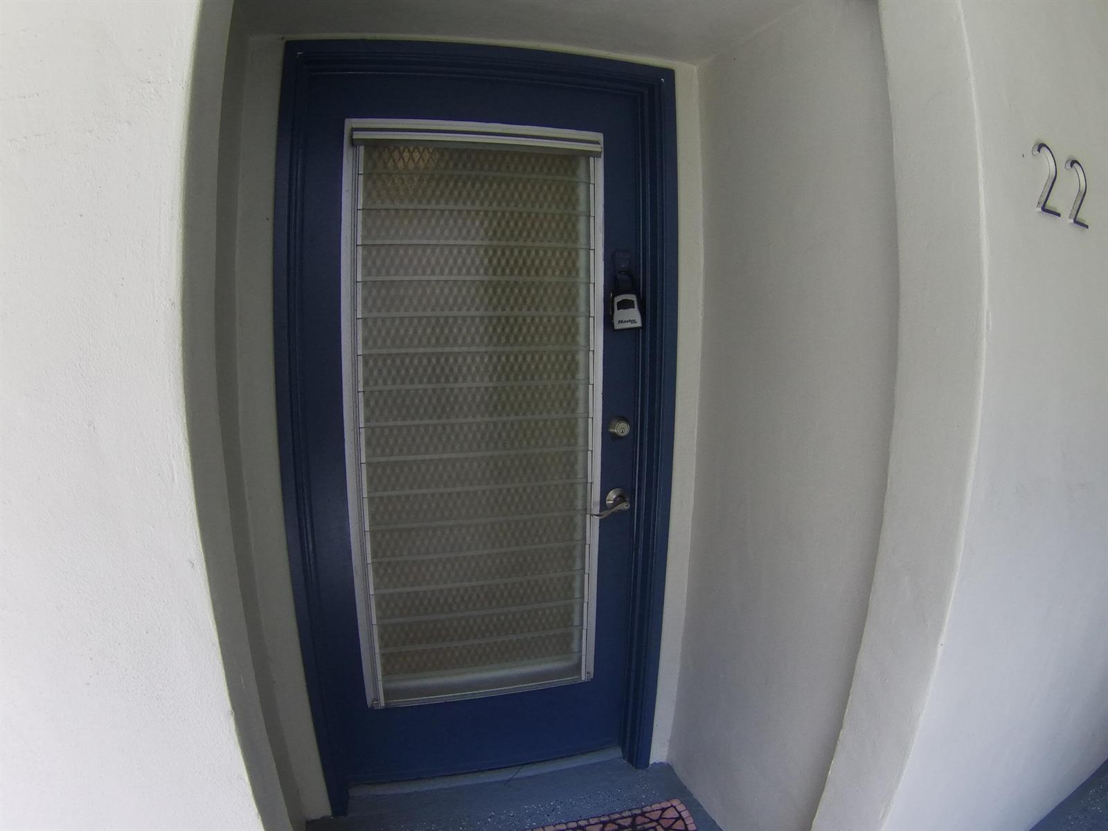 A blue front door with a glass insert and a lockbox, marked with the number 22 — 22 CAPRI A, Delray Beach FL 33484, DELRAY BEACH, FL