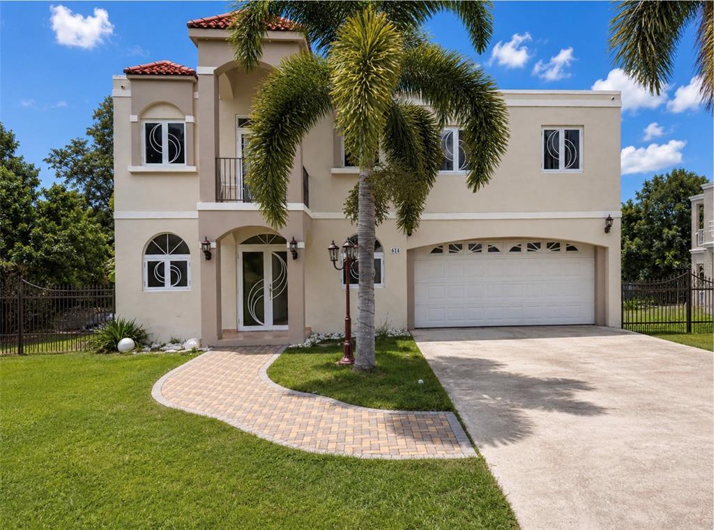 A bright, tiled living room features a decorative glass door, arched window, and wooden staircase — Urb. Morovis del Norte #614 CALLE URUGUAY, MOROVIS, PR