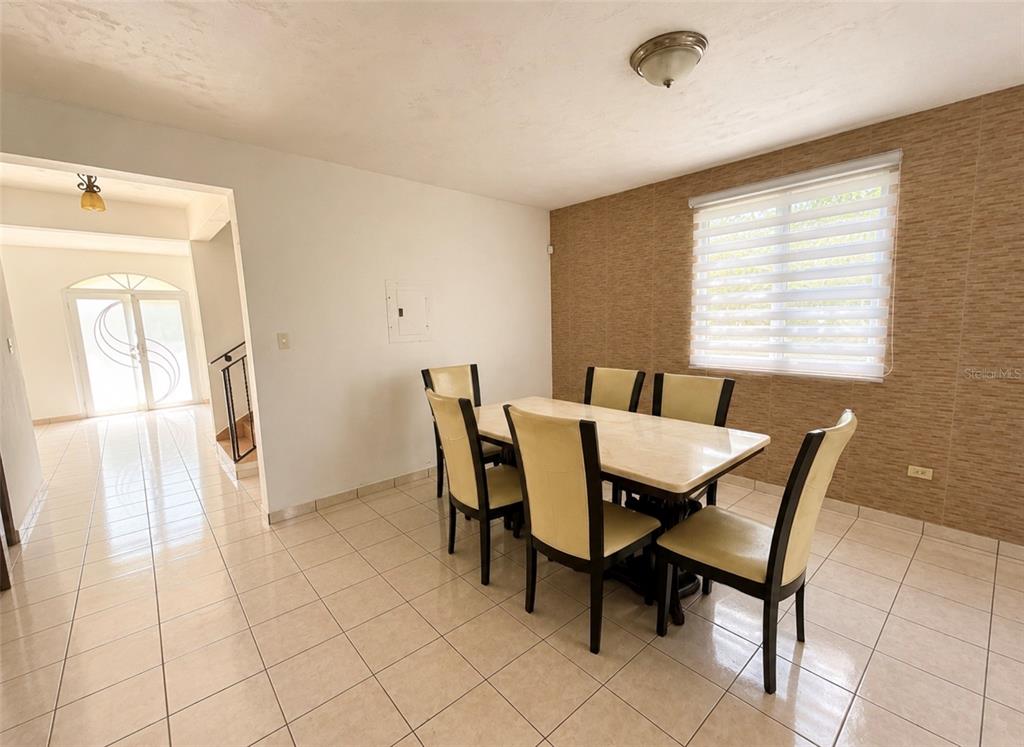 A kitchen features wood cabinetry, a stainless steel refrigerator, a peninsula, and light-colored tile flooring — Urb. Morovis del Norte #614 CALLE URUGUAY, MOROVIS, PR