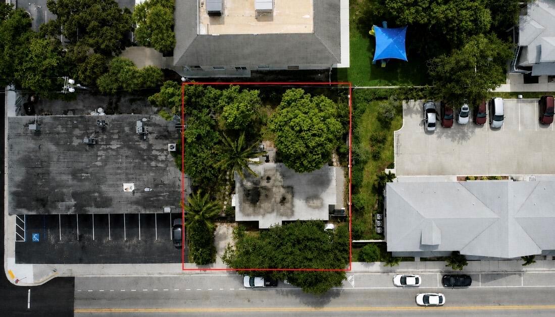 An aerial view shows a rectangular lot with a house surrounded by trees and parking — 211 N A Street, FL 33460, FL