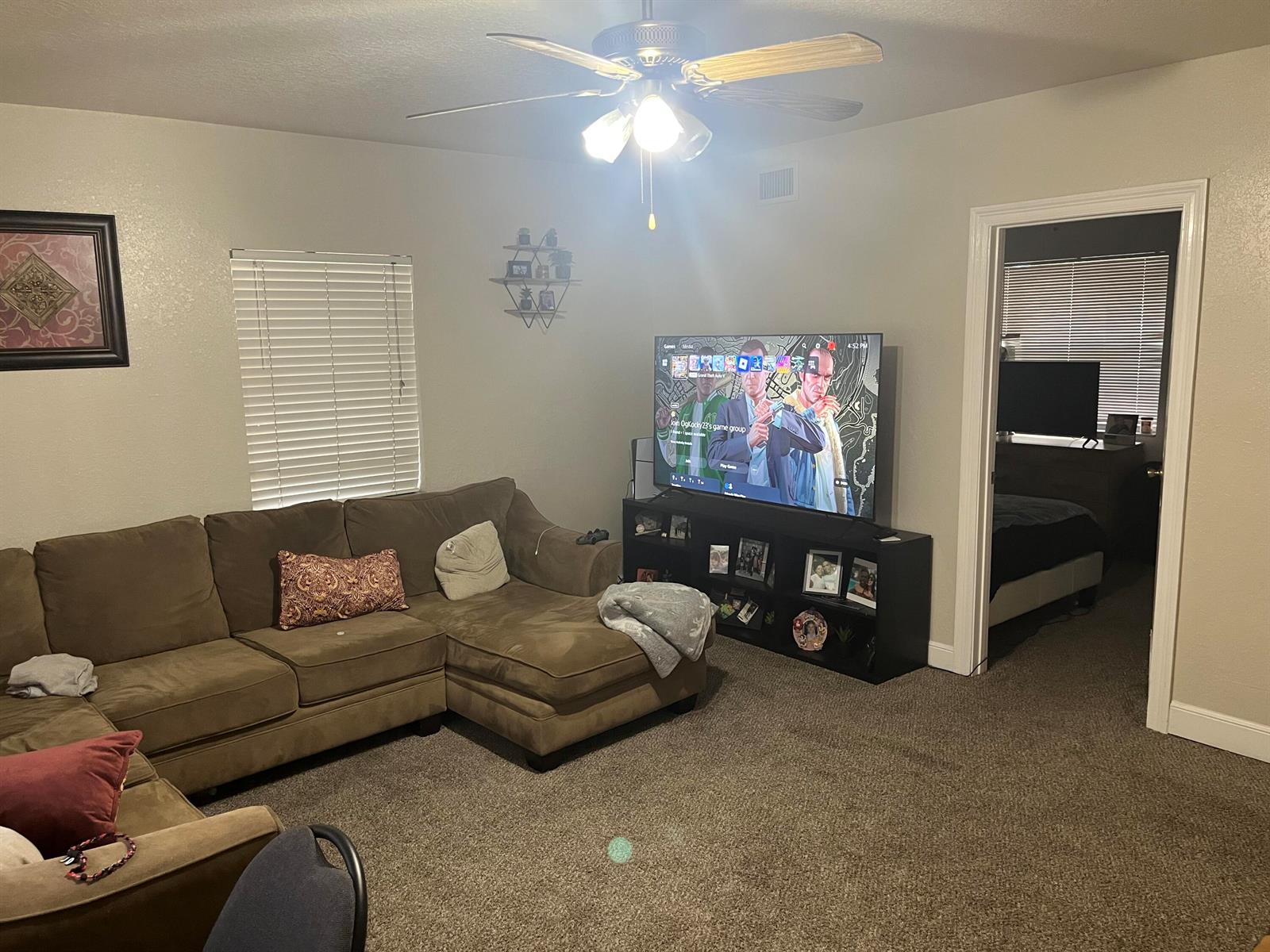 A living room features a brown sectional sofa, a television on a black stand, and carpet — 211 N A Street, FL 33460, FL