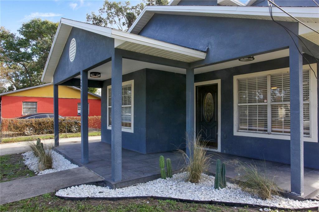 A blue house with a covered front porch, white gravel landscaping, and cacti — 822 POLK STREET, ORLANDO, FL