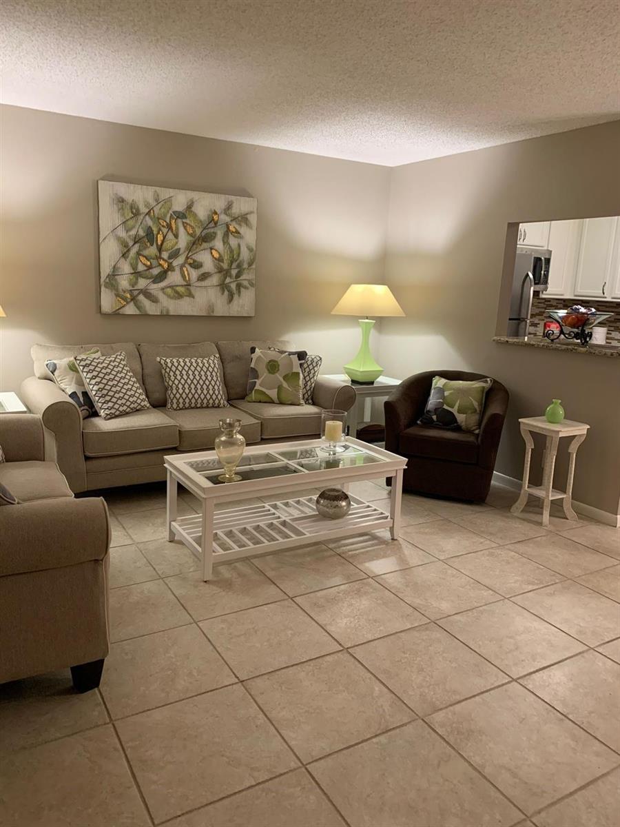 A living room features a beige sofa, a brown armchair, and a white coffee table — 87 FANSHAW C # 87, Boca Raton FL 33434, BOCA RATON, FL