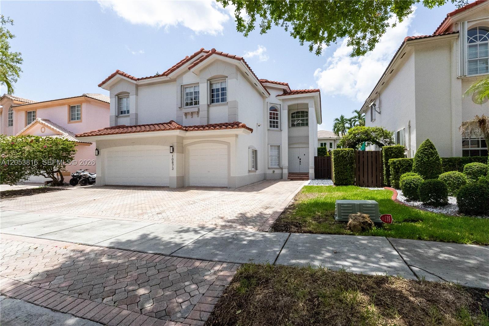 A two-story suburban house with a tiled roof, two-car garage, and a paved driveway — 10873 NW 71st St, Doral FL 33178, DORAL, FL