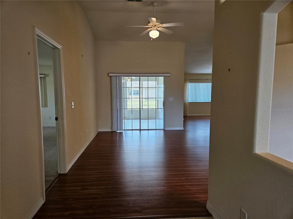 A living area features wood-look flooring, a ceiling fan, and sliding glass doors to a patio — 5954 SW 98TH STREET ROAD, OCALA, FL