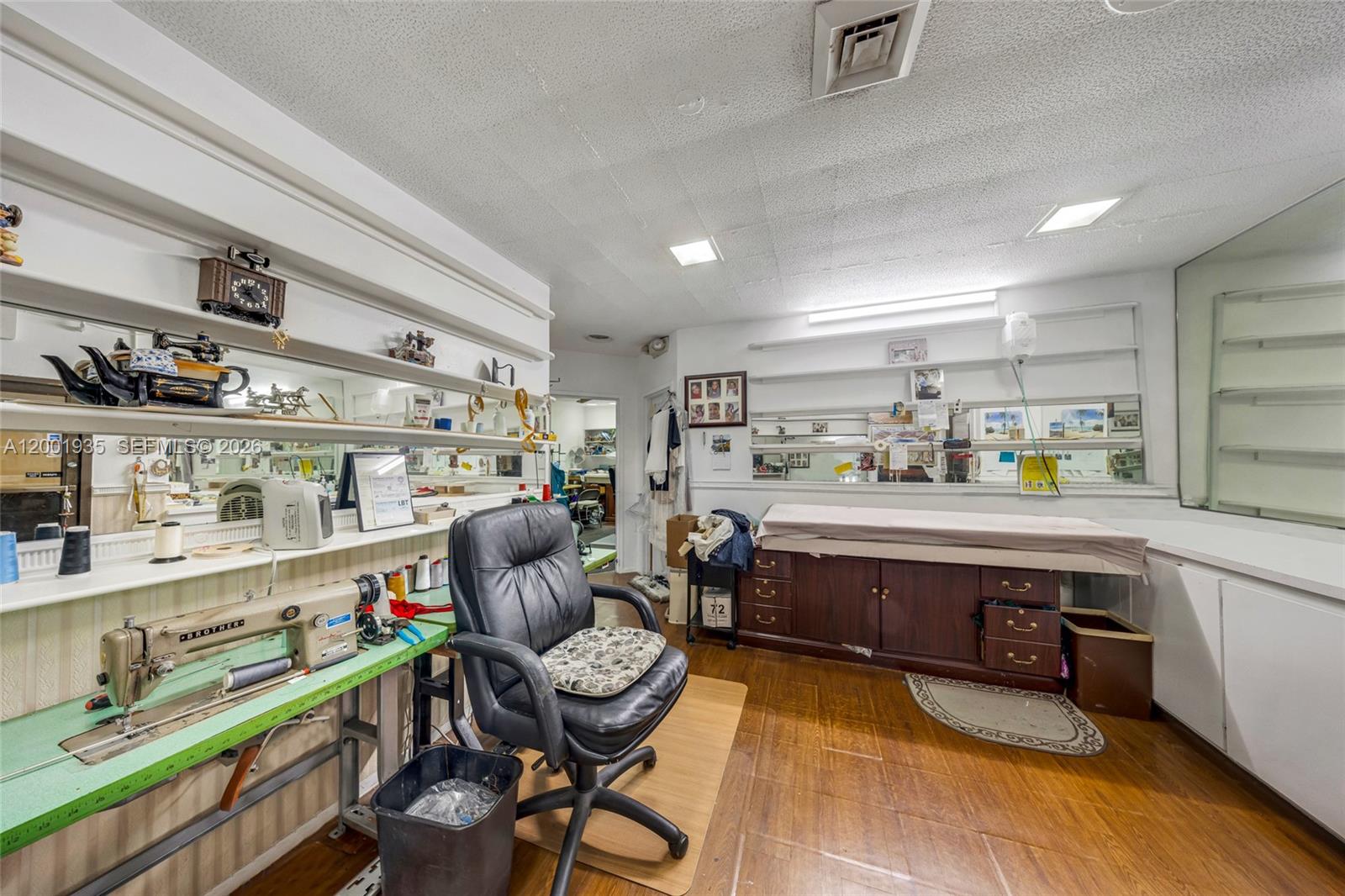 A sewing room features a Brother sewing machine, a leather office chair, and wooden cabinetry — 5401 Collins Ave # 9, Miami Beach FL 33140, MIAMI BEACH, FL