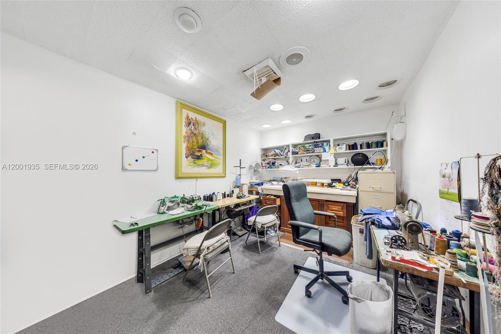 A sewing and craft room features multiple workstations, sewing machines, shelving, and a rolling chair — 5401 Collins Ave # 9, Miami Beach FL 33140, MIAMI BEACH, FL