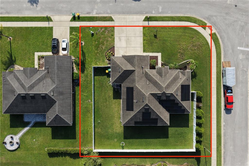 An aerial view shows a single-family home with solar panels and a fenced backyard — 700 ELKHORN FERN LANE, DELAND, FL