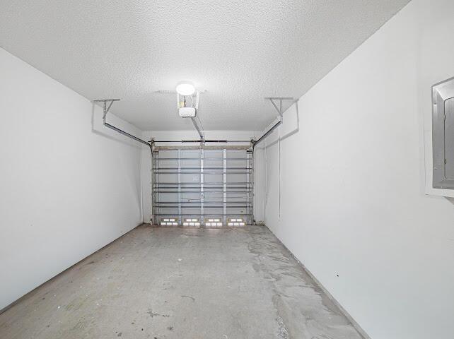 An empty, white-walled garage with a concrete floor and a metal overhead door — 8596 Jade Drive, Tamarac FL 33321, TAMARAC, FL