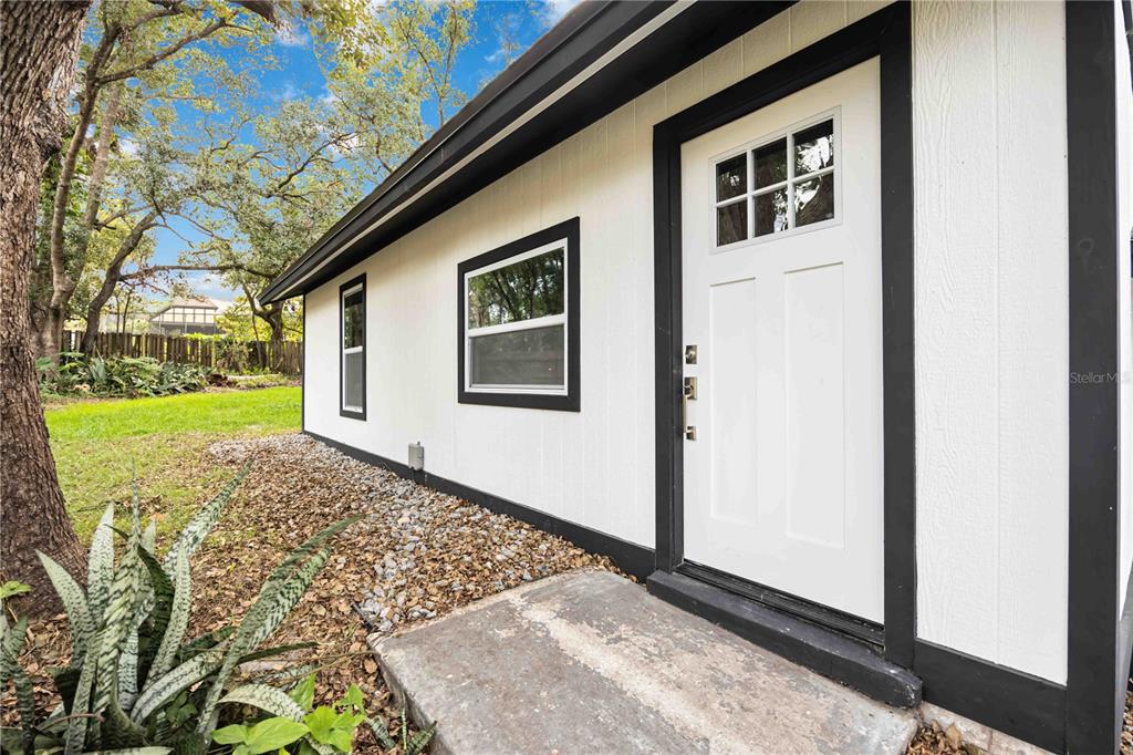 A white exterior wall with black trim, a white door, and two windows — 5433 579 HIGHWAY UNIT A, SEFFNER, FL