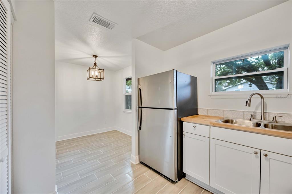 A kitchen with white cabinets, a stainless steel refrigerator, and a wood countertop — 5433 579 HIGHWAY UNIT A, SEFFNER, FL