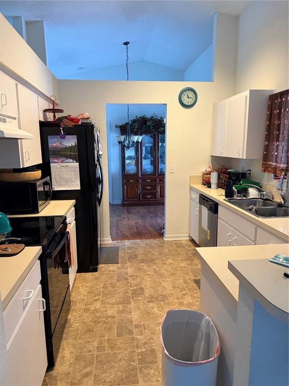 A kitchen with white cabinets, black appliances, and a doorway leading to a dining area — 3875 HORIZON HILL DRIVE, LAKELAND, FL