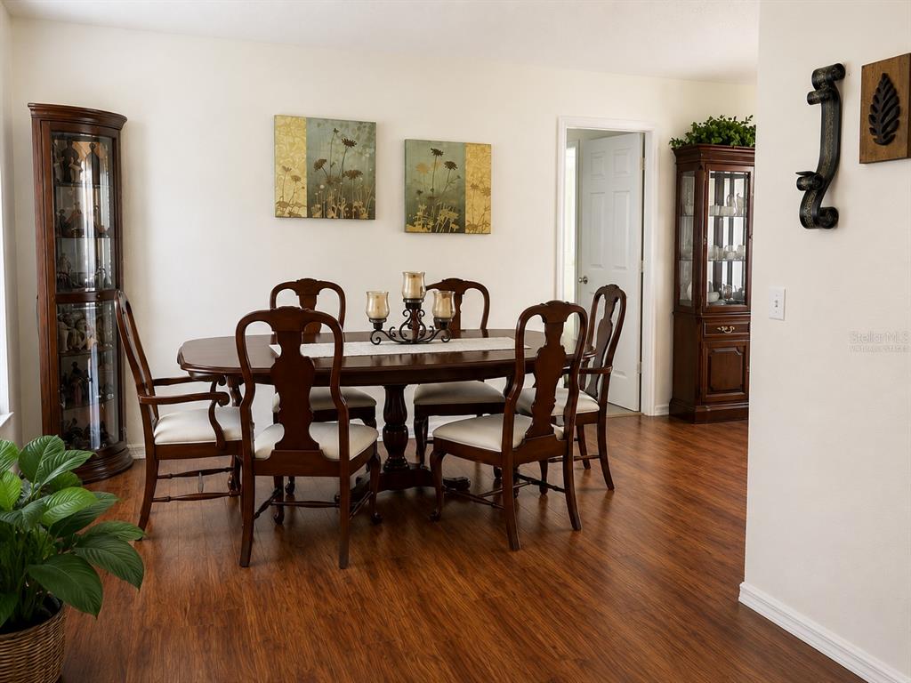 A dining room features a wooden table with six chairs, two curio cabinets, and artwork — 3875 HORIZON HILL DRIVE, LAKELAND, FL