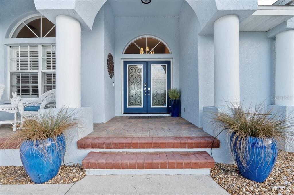 A blue double front door with glass inserts sits behind two steps and white columns — 1091 ROTONDA CIRCLE, ROTONDA WEST, FL